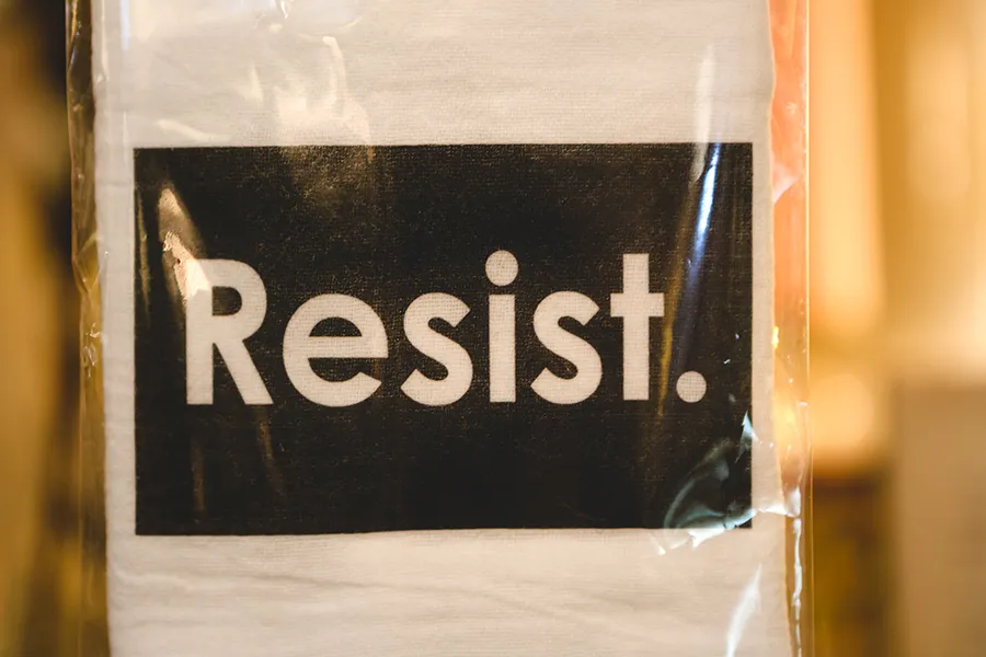 A sign with the word Resist printed on it.